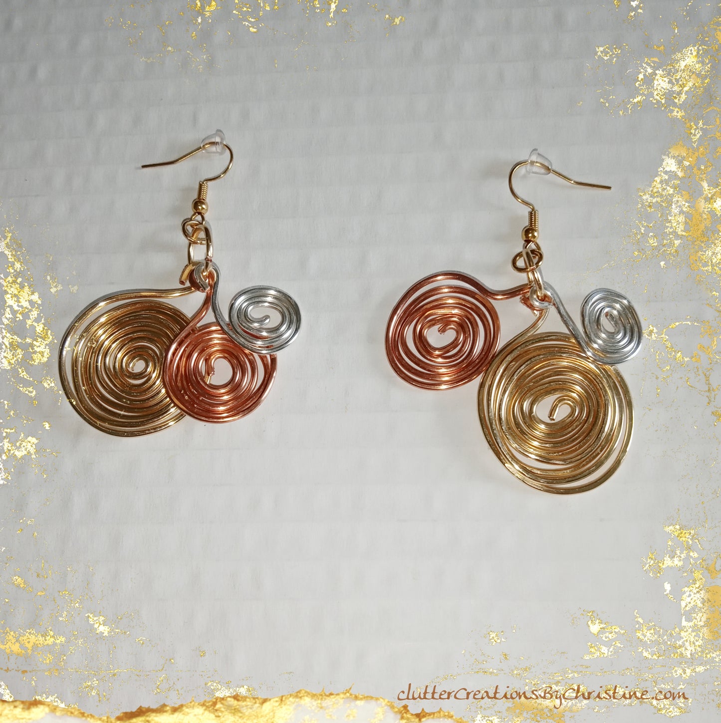 Handmade One-of-a-kind earrings feature a spiral design in gold, silver, and copper colors, creating a fun and stylish look. Crafted with tarnish-resistant copper wire and 18 kt gold plated hooks.